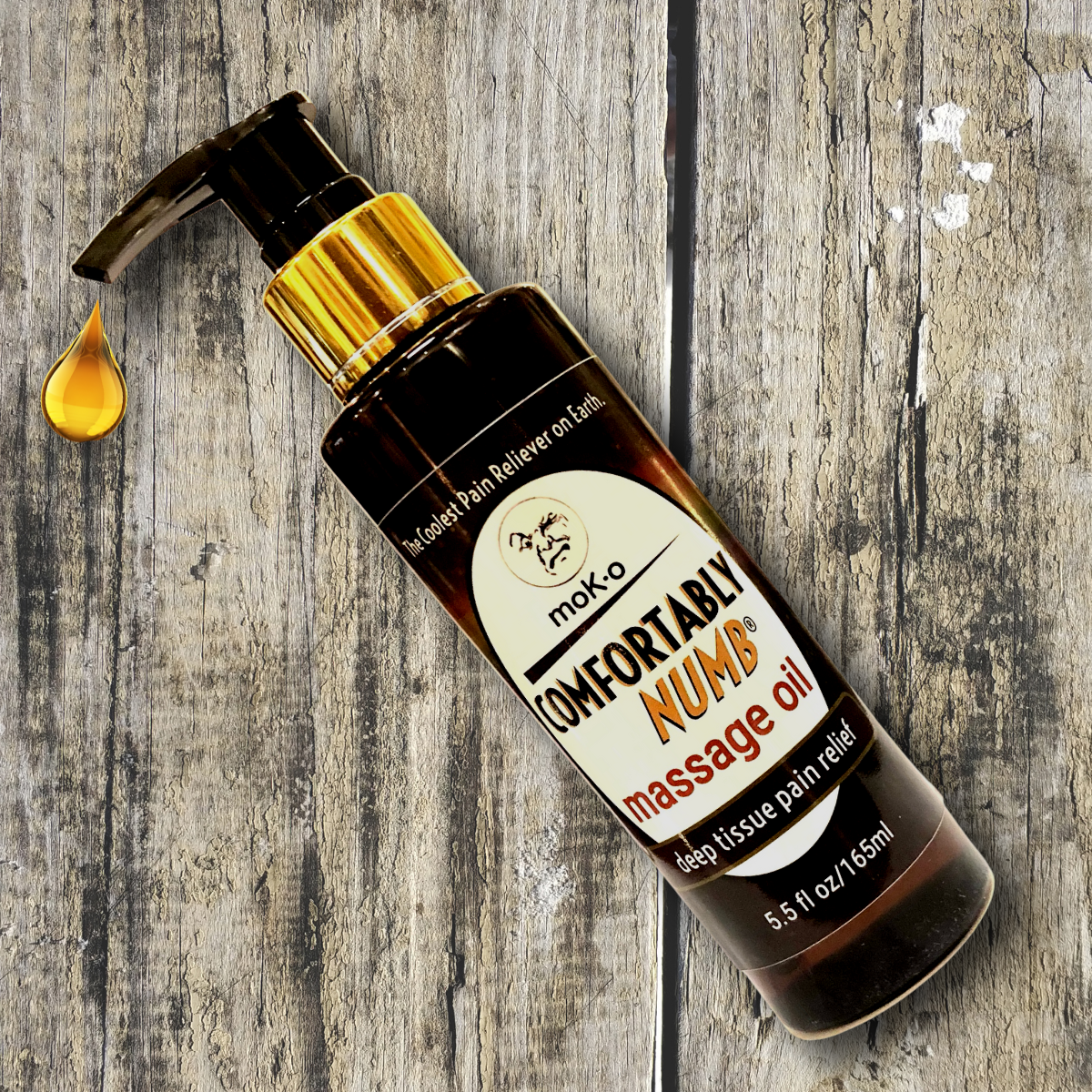 Comfortably Numb's HOT NEW PRODUCT. A deep tissue massage oil with the infamous Comfortably Numb Oil combined with ylang ylang and ginger oil. on a wood plank.